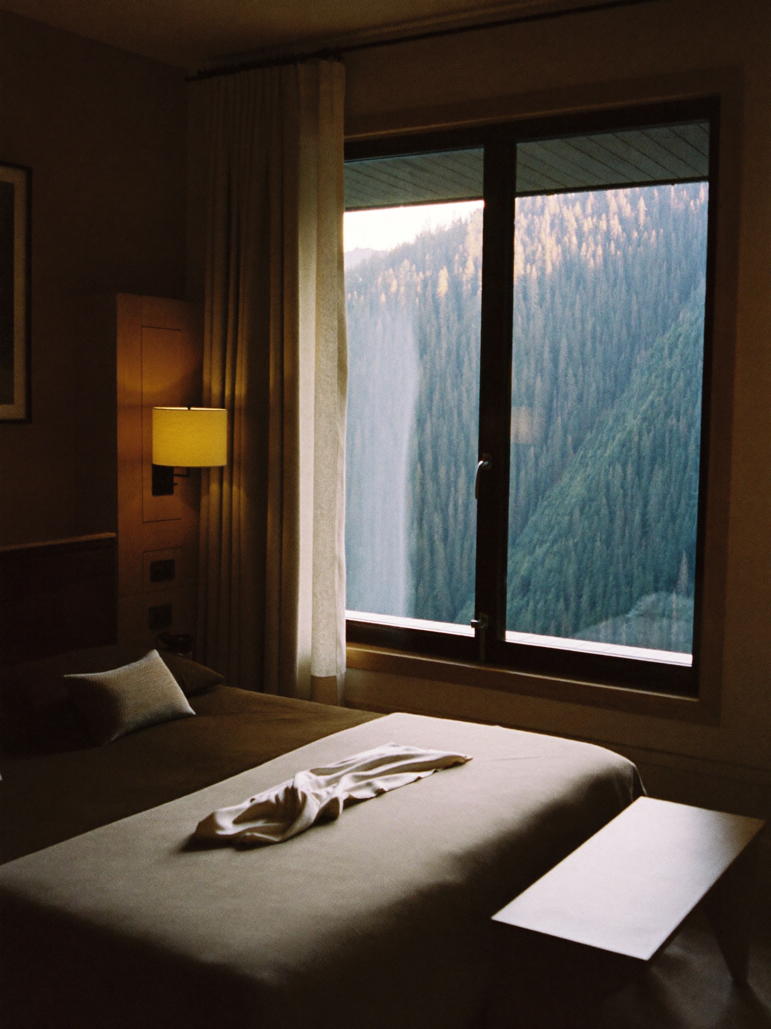 Lodge suite interior with morning light across a linen bed